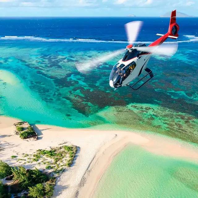 Helicopter above a turquoise coastal lagoon in Mauritius